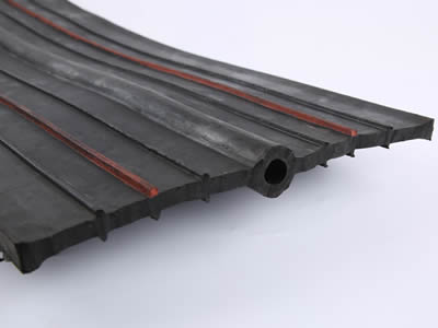 Buried reinforced rubber waterstop with round bulb and six stems in which is two swelling strips.