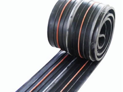 A roll of reinforced rubber waterstop with two orange swelling strips.